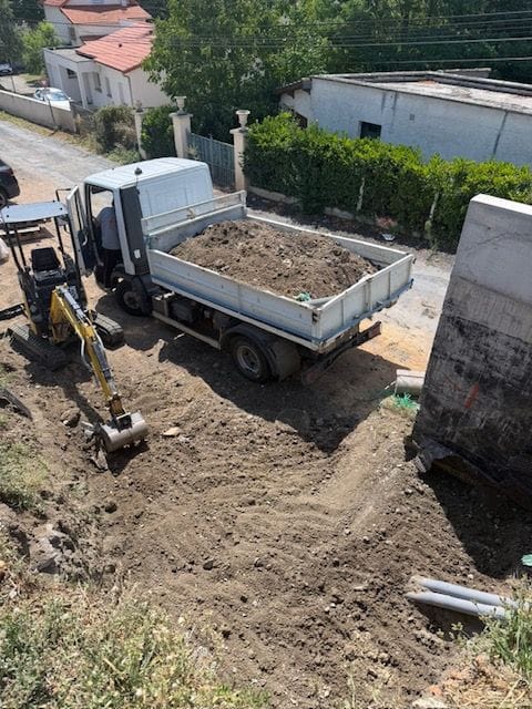 Mini-pelle et camion benne chargé de déblais sur un chantier de terrassement au nord de Clermont-Ferrand